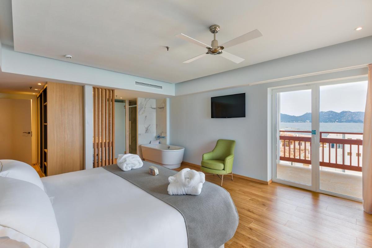 1 dormitorio con 1 cama blanca grande y balcón en Talayot - Adults Only, en Cala Millor 108 fotos más