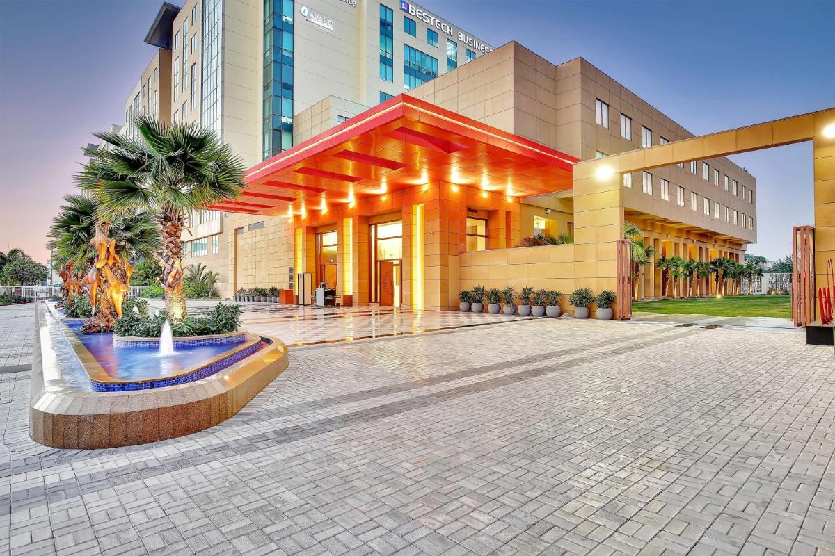 a large building with palm trees in front of it at Radisson RED Chandigarh Mohali in Chandīgarh
