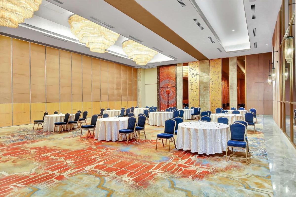 a banquet hall with white tables and blue chairs at Radisson RED Chandigarh Mohali in Chandīgarh +89 photos