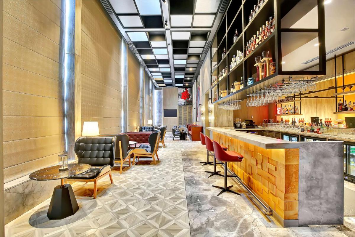 a lobby of a hotel with a bar and chairs at Radisson RED Chandigarh Mohali in Chandīgarh