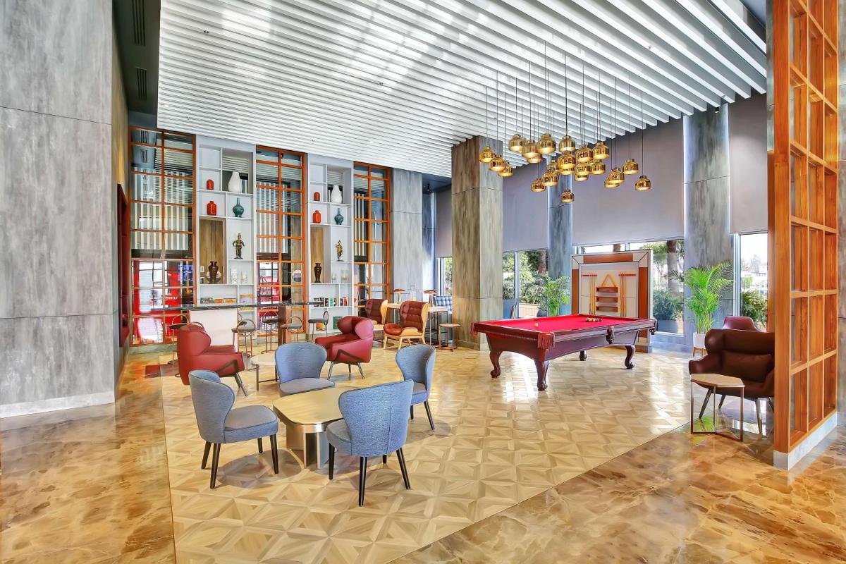 a living room with a pool table and chairs at Radisson RED Chandigarh Mohali in Chandīgarh