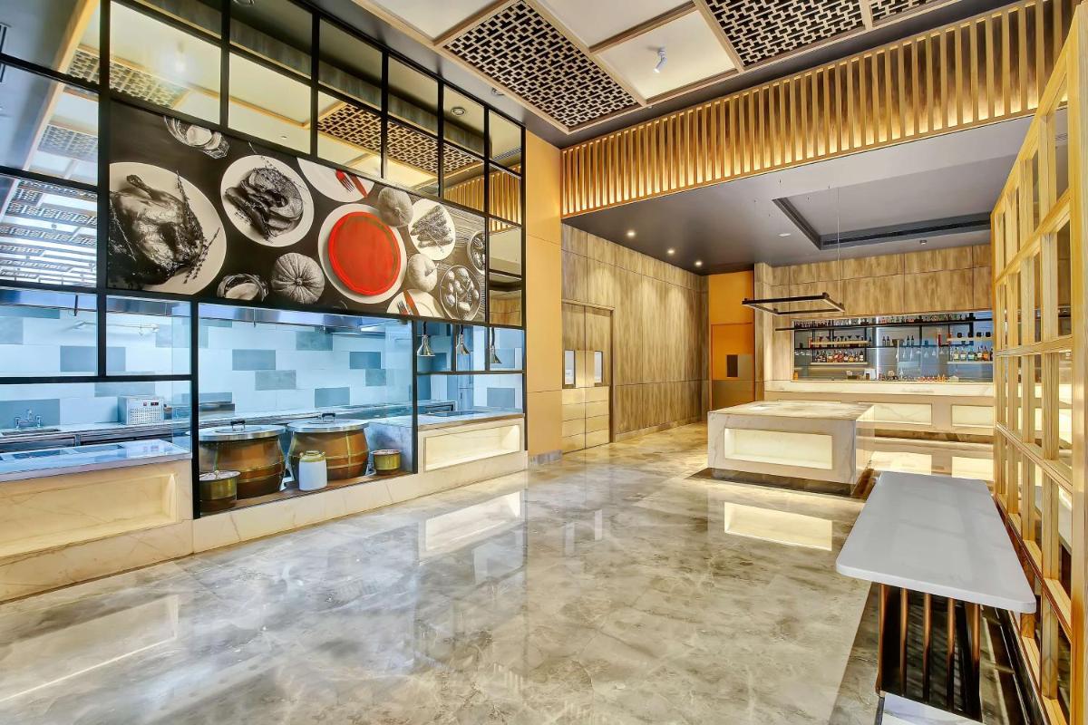 a dining room with a table and a large window at Radisson RED Chandigarh Mohali in Chandīgarh
