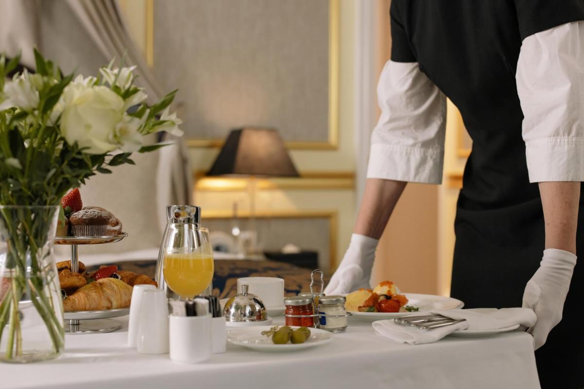 a person standing in front of a table with food at ZANA Lakeview Resort - most scenic lakeside resort in Udaipur