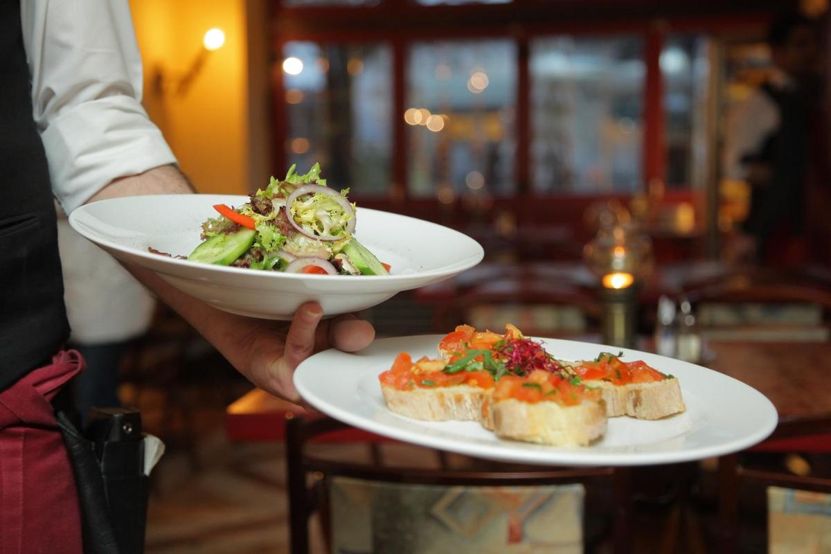 a person holding a plate of food with a salad and bread at ZANA Lakeview Resort - most scenic lakeside resort in Udaipur