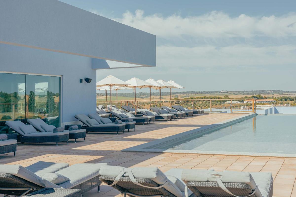 uma piscina com espreguiçadeiras no telhado em Sleep & Nature Hotel em Lavre