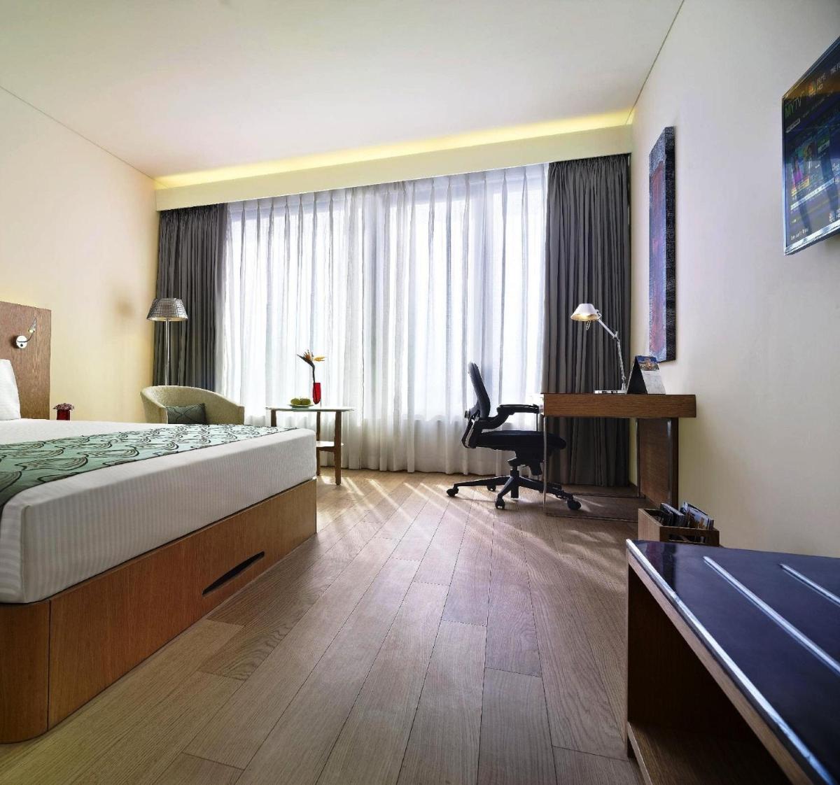 a hotel room with a bed and a desk at Vivanta Chennai IT Expressway OMR in Chennai