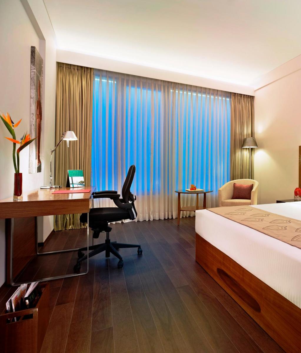 a hotel room with a bed and a desk and a computer at Vivanta Chennai IT Expressway OMR in Chennai