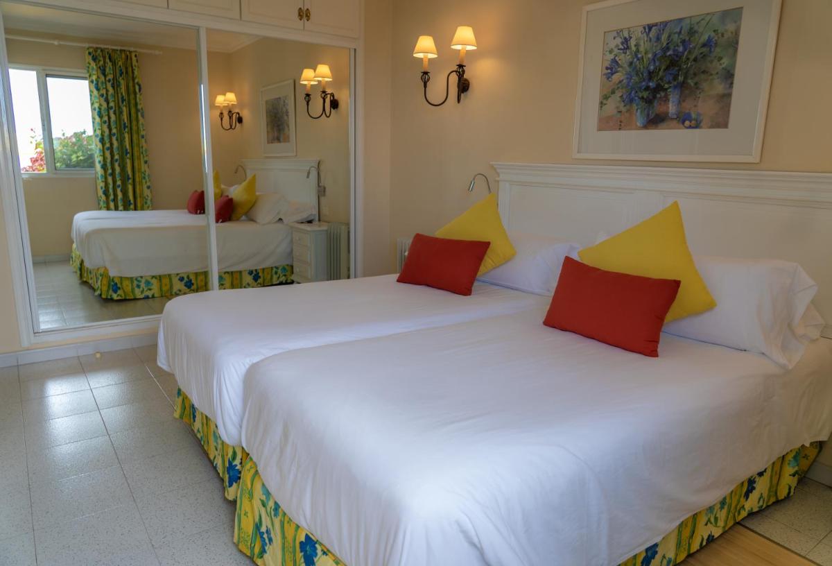 Una habitación de hotel con dos camas y un espejo. en La Palma Jardín Resort, en El Paso 23 fotos más