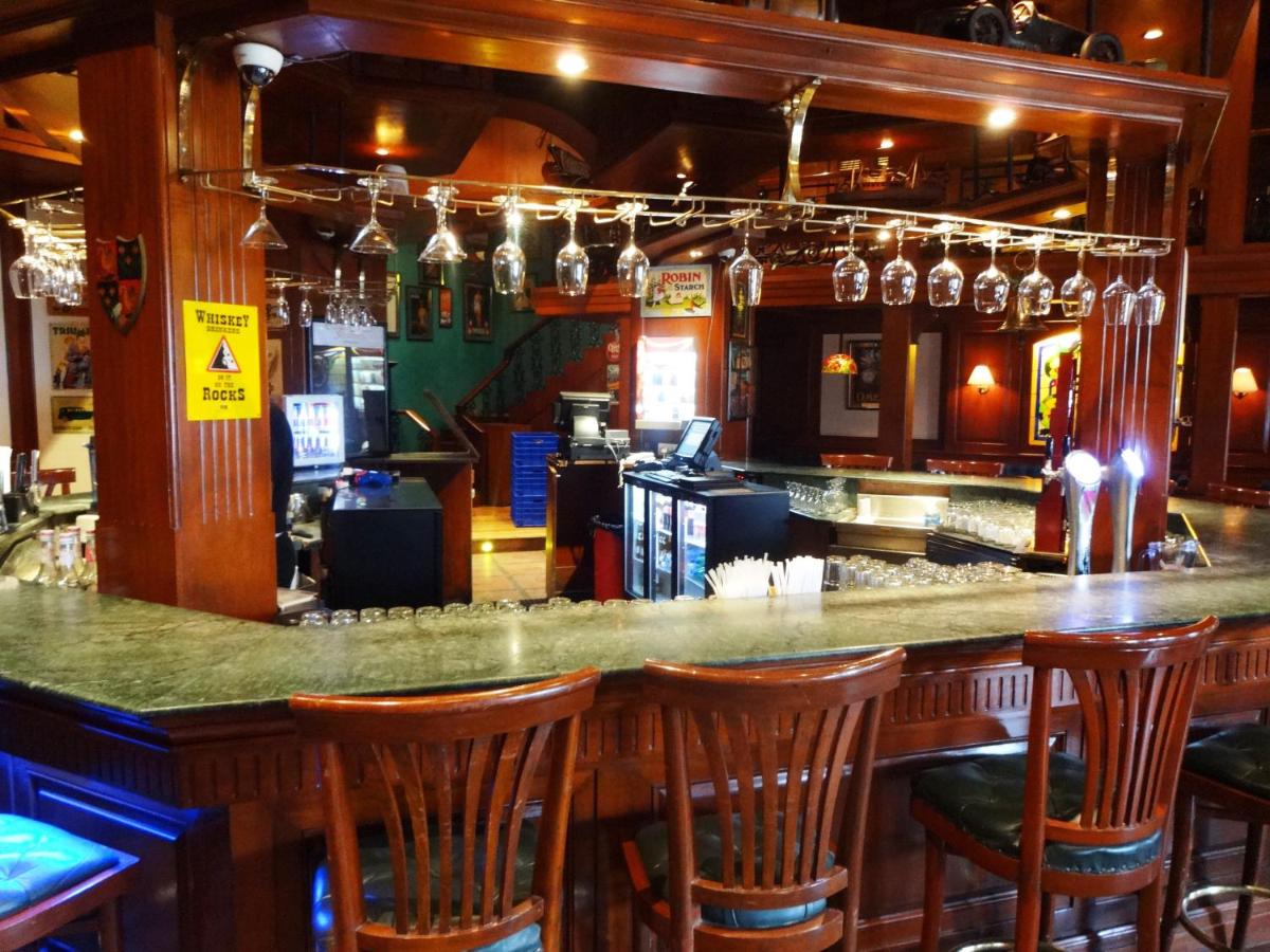 a bar with wooden bar stools in a restaurant at Hotel Royal Orchid Bangalore in Bengaluru
