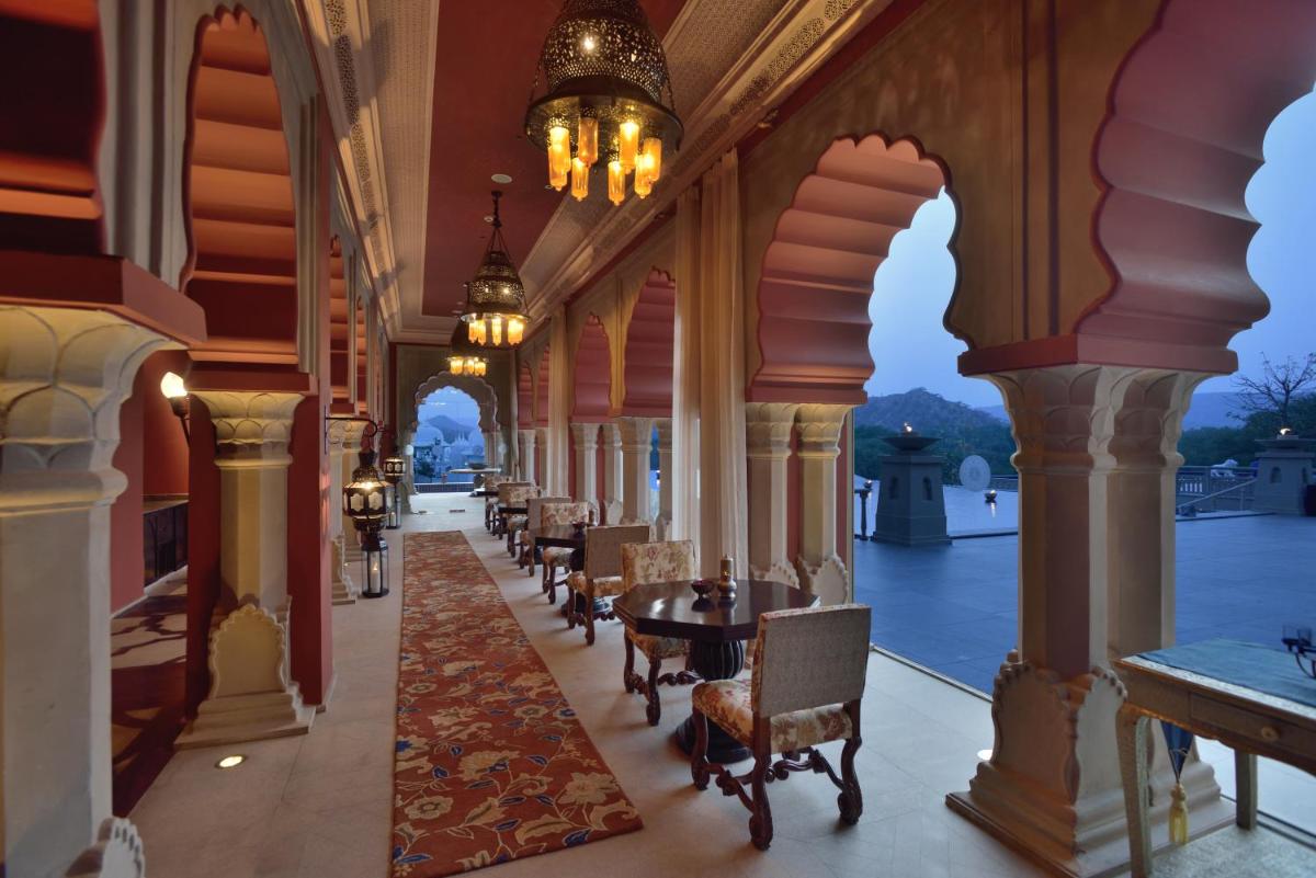 a corridor of a building with tables and chairs at Fairmont Jaipur in Jaipur