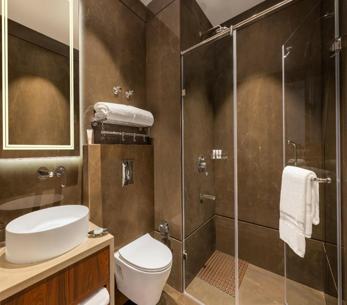 a bathroom with a toilet and a glass shower at WelcomHeritage Elysium Resort & Spa in Shimla