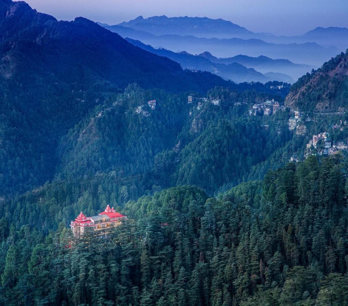 a large building in the middle of a mountain at WelcomHeritage Elysium Resort & Spa in Shimla