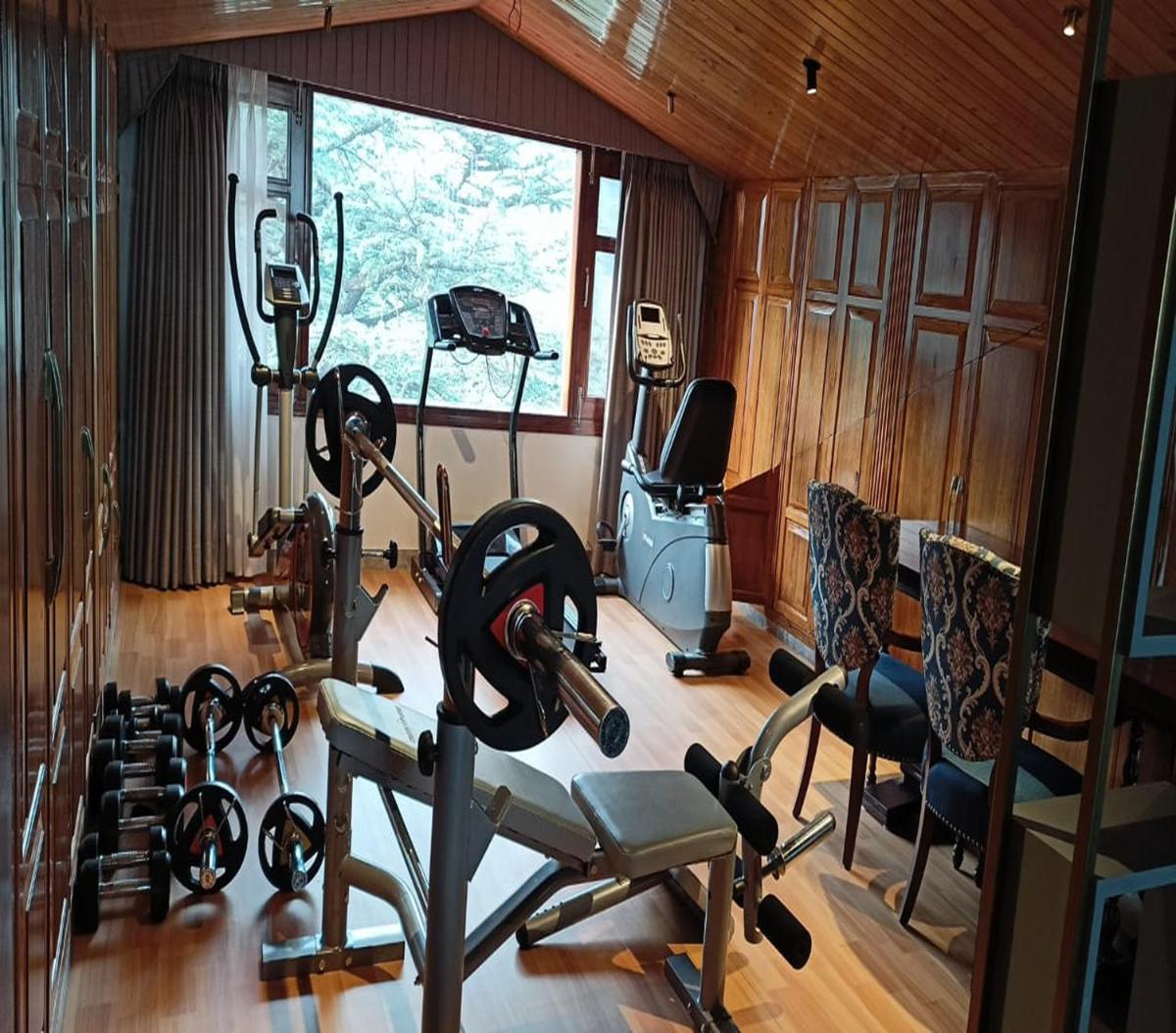a gym with several exercise equipment in a room at WelcomHeritage Elysium Resort & Spa in Shimla