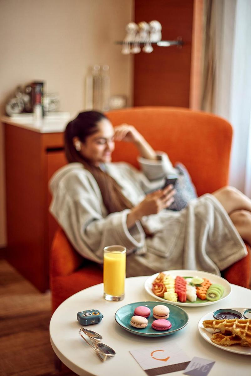 a woman sitting in a chair with a table with food at Hyatt Centric Janakpuri New Delhi in New Delhi