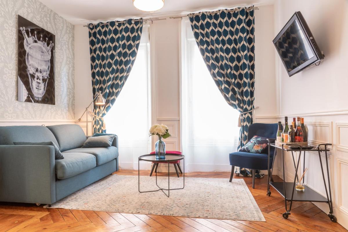 un salon avec un canapé et une table dans l'établissement TOWNHOUSE TROUVILLE - Appart'Hotel & Studios, à Trouville-sur-Mer