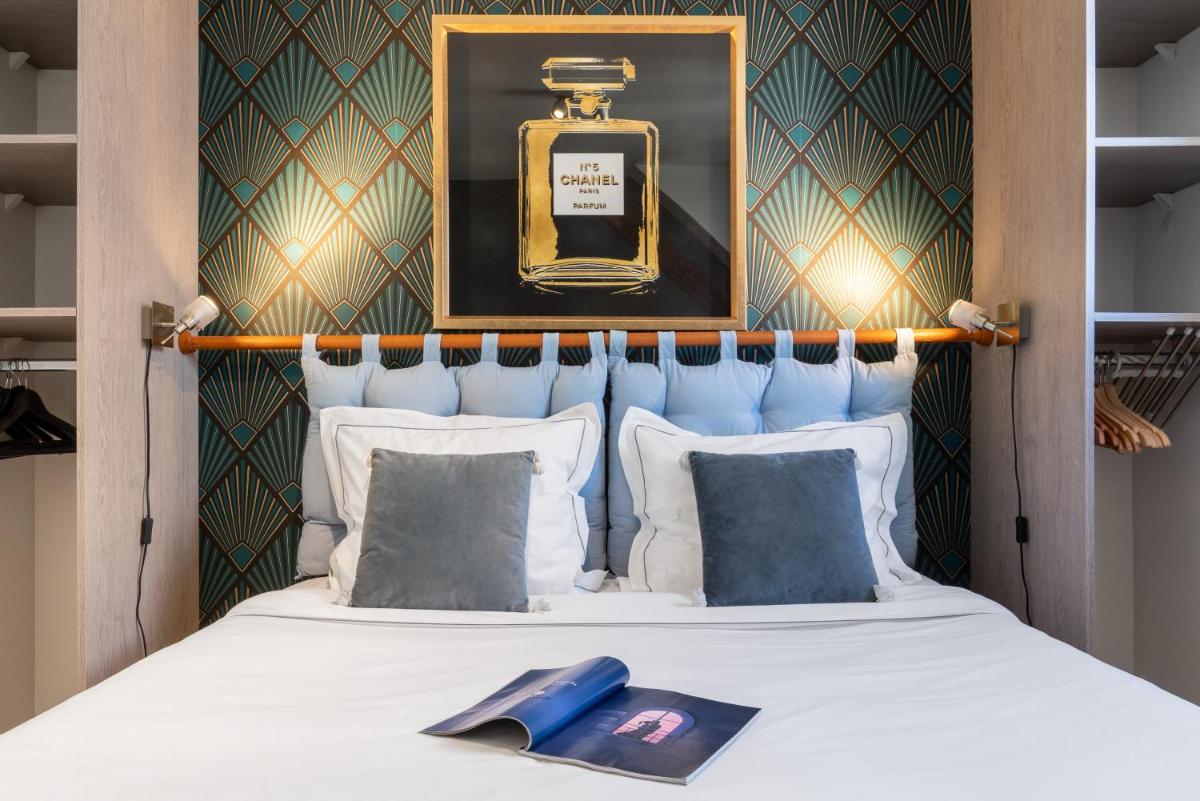 une chambre avec un lit avec un flacon de parfum dans l'établissement TOWNHOUSE TROUVILLE - Appart'Hotel & Studios, à Trouville-sur-Mer