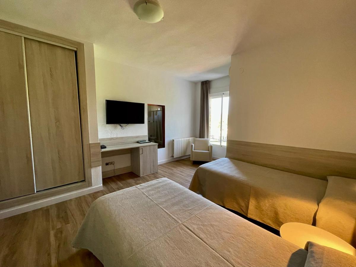 Una habitación de hotel con una cama y un televisor de pantalla plana. en Hotel Balneario Fuentes del Trampal, en Carmonita