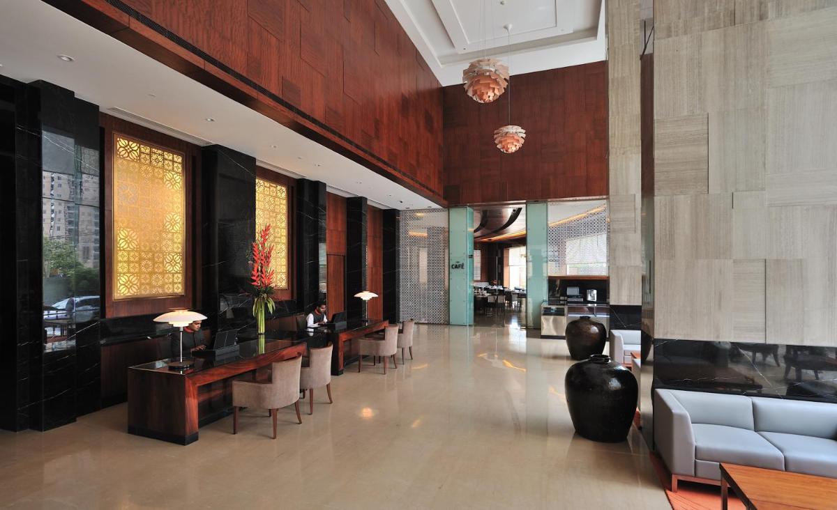 a lobby with chairs and tables in a building at The Anya Hotel-Golf Course Road in Gurgaon