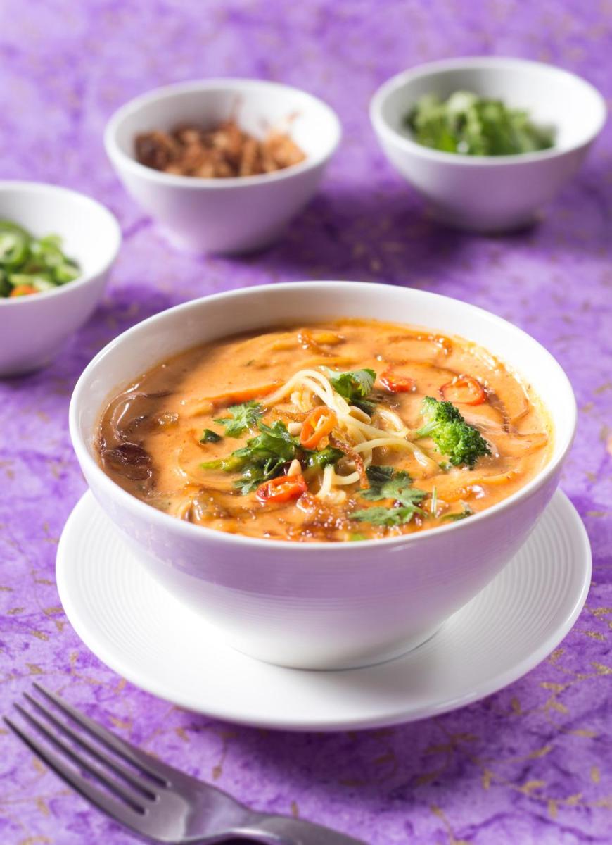 a bowl of soup on a plate on a table at The Anya Hotel-Golf Course Road in Gurgaon