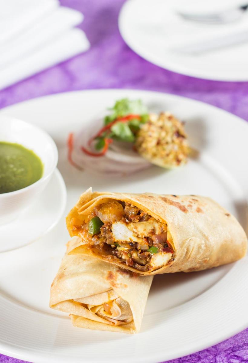 a plate of food with a burrito and a bowl of soup at The Anya Hotel-Golf Course Road in Gurgaon