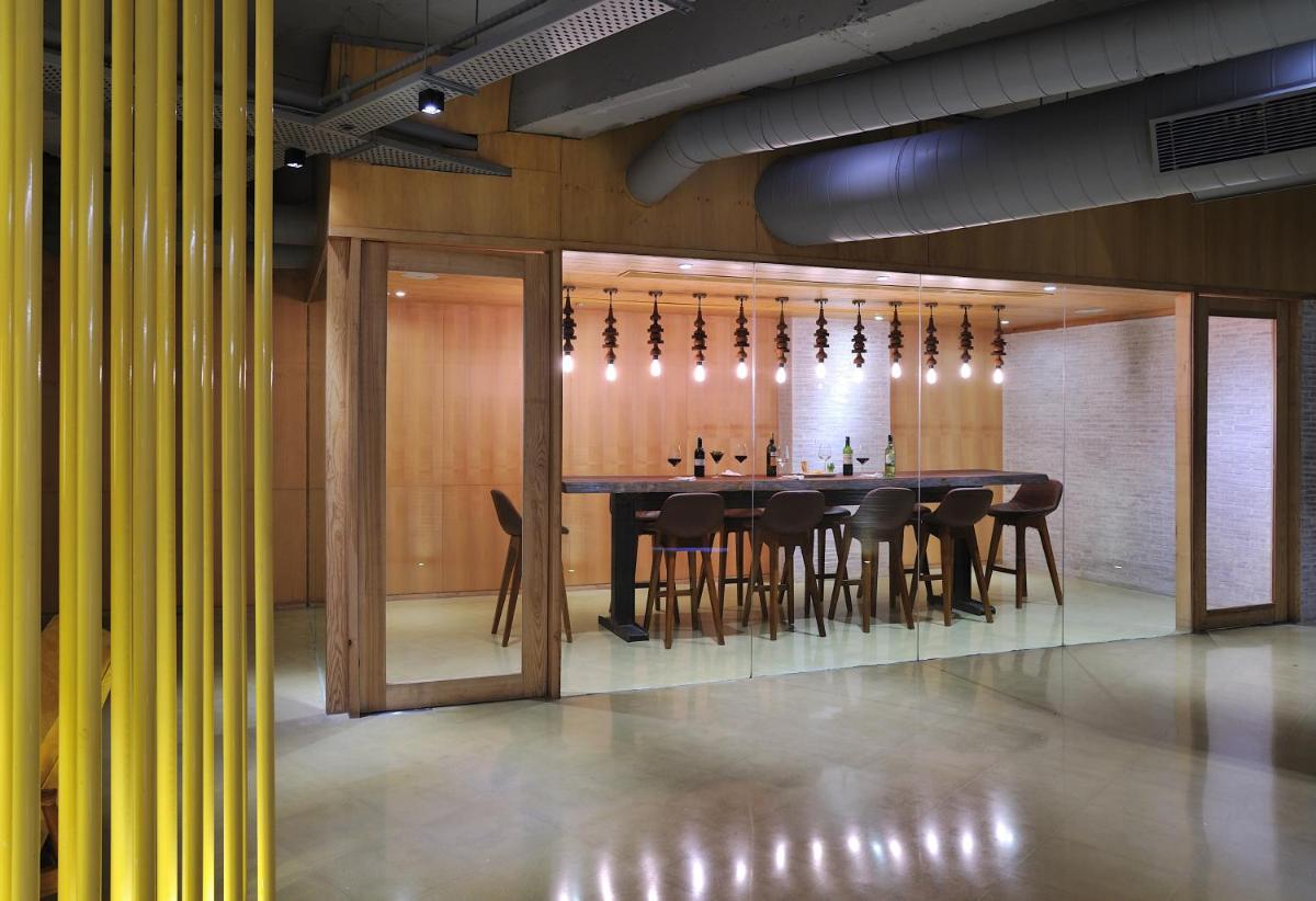 a dining room with a long table and chairs at The Anya Hotel-Golf Course Road in Gurgaon