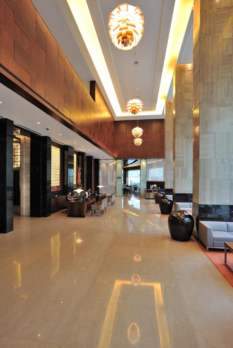 a lobby with couches and tables in a building at The Anya Hotel-Golf Course Road in Gurgaon
