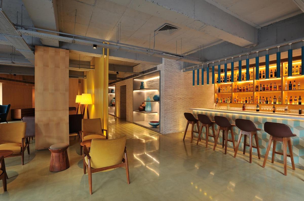 a bar in a restaurant with bar stools at The Anya Hotel-Golf Course Road in Gurgaon