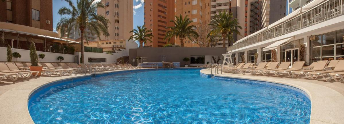 Una gran piscina en un hotel con sillas. en RH Princesa Hotel & Spa 4* Sup, en Benidorm