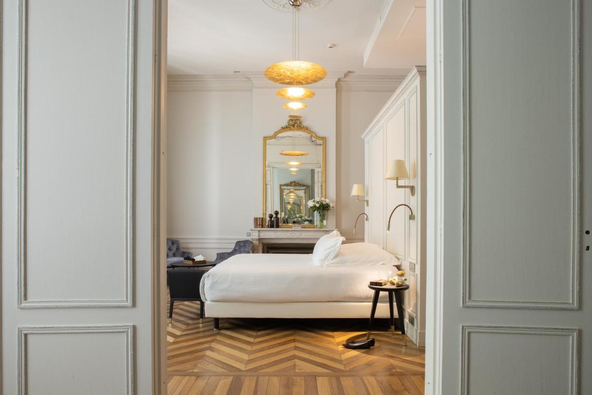 une chambre avec un lit blanc et un miroir dans l'établissement Villas Foch Boutique Hotel & Spa Bordeaux, à Bordeaux