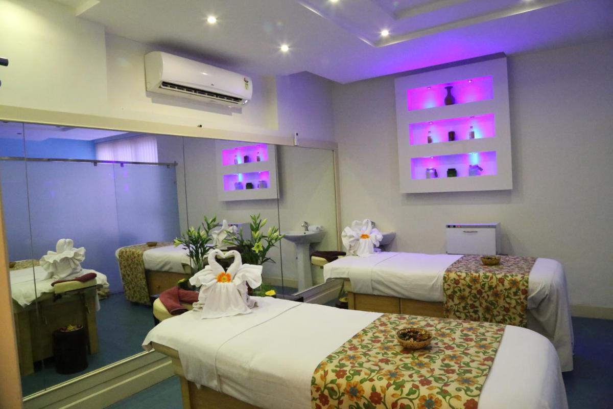 a hospital room with two beds and purple lights at Hotel Clarks Shiraz in Agra