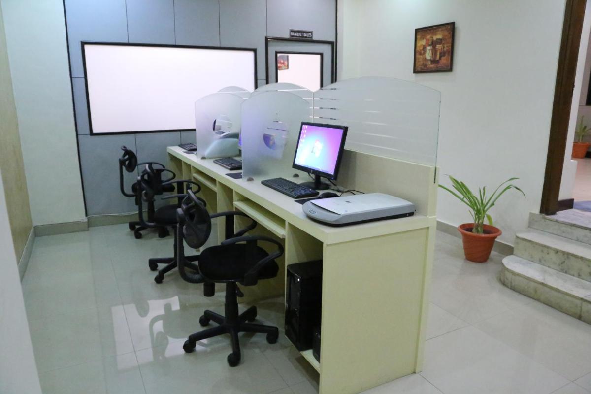 an office with a desk with a laptop computer on it at Hotel Clarks Shiraz in Agra