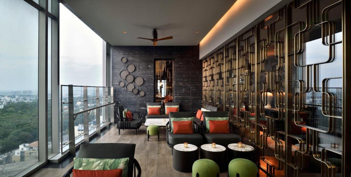 a room with couches and tables and windows at Four Seasons Hotel Bengaluru at Embassy ONE in Bengaluru a room with couches and tables and windows at Four Seasons Hotel Bengaluru at Embassy ONE in Bengaluru