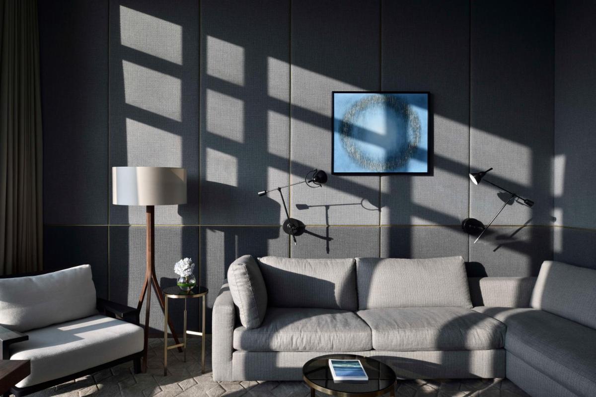 a living room with a couch and a tv on a wall at Four Seasons Hotel Bengaluru at Embassy ONE in Bengaluru a living room with a couch and a tv on a wall at Four Seasons Hotel Bengaluru at Embassy ONE in Bengaluru