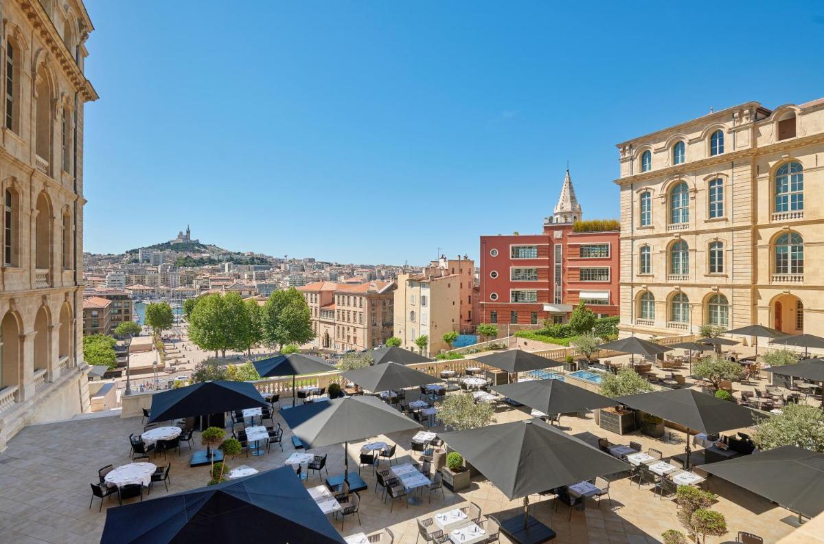vue aérienne d'une ville avec des tables et des parasols dans l'établissement InterContinental Marseille - Hotel Dieu by IHG, à Marseille