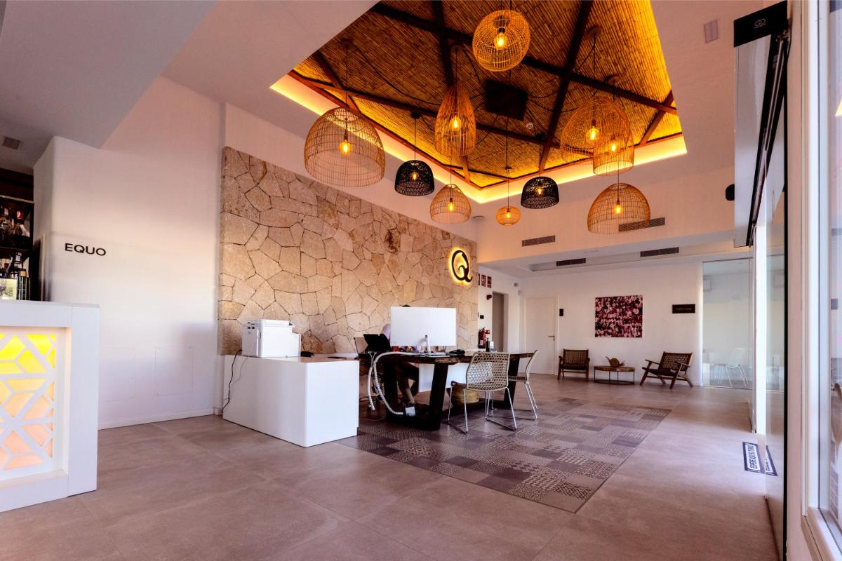 Habitación con mesa, sillas y pared con luces. en Eques Petit Resort, en Cala d´Or