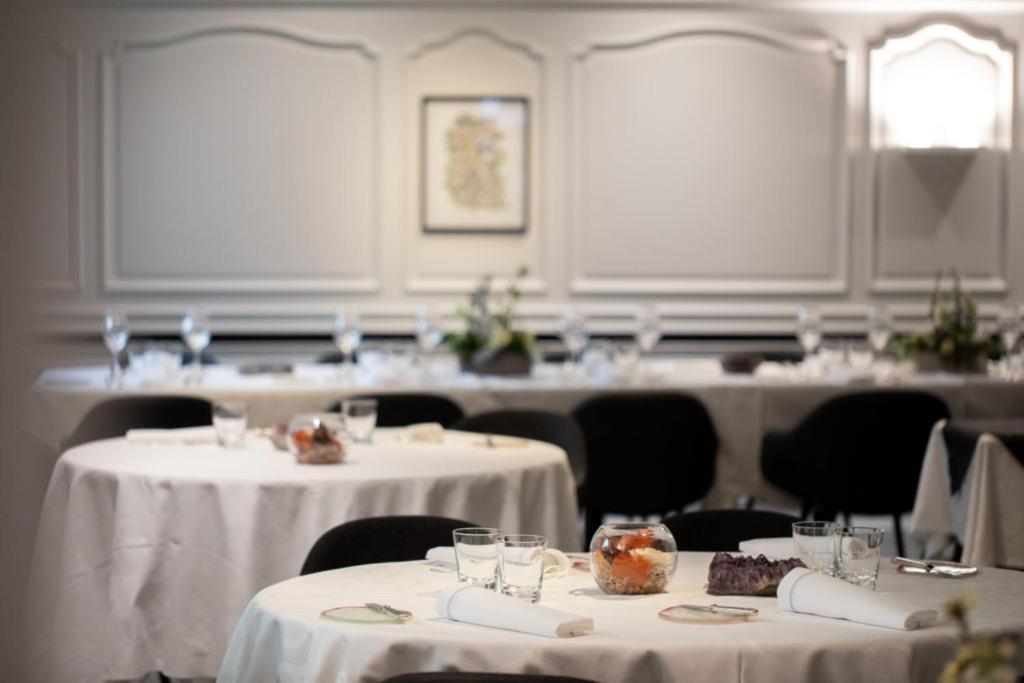 une pièce avec des tables et des chaises avec des nappes blanches dans l'établissement Auberge du Cheval Blanc depuis 1785, à Westhalten