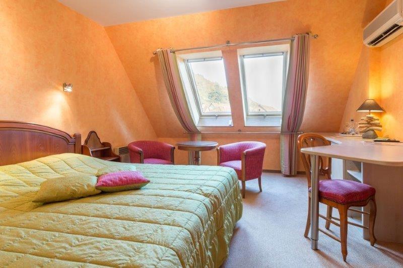 une chambre avec un lit, une table et une fenêtre dans l'établissement Auberge du Cheval Blanc depuis 1785, à Westhalten
