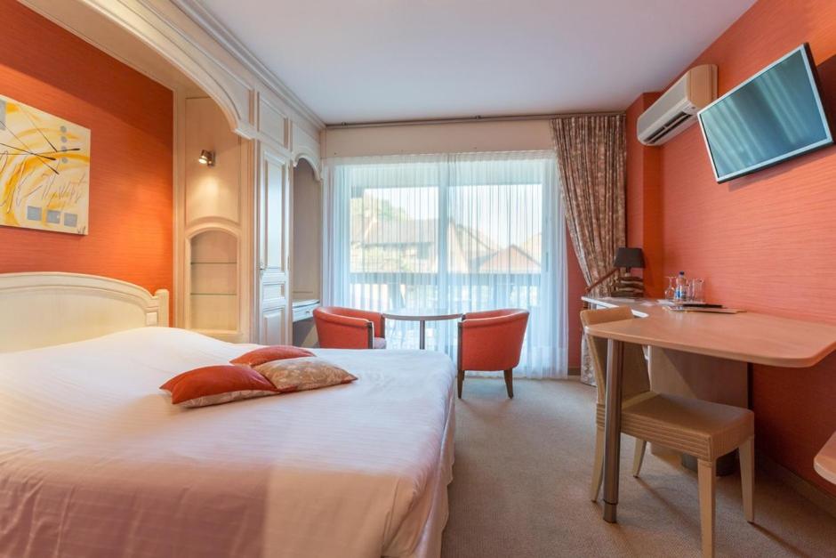 une chambre d'hôtel avec un lit, un bureau et une table dans l'établissement Auberge du Cheval Blanc depuis 1785, à Westhalten