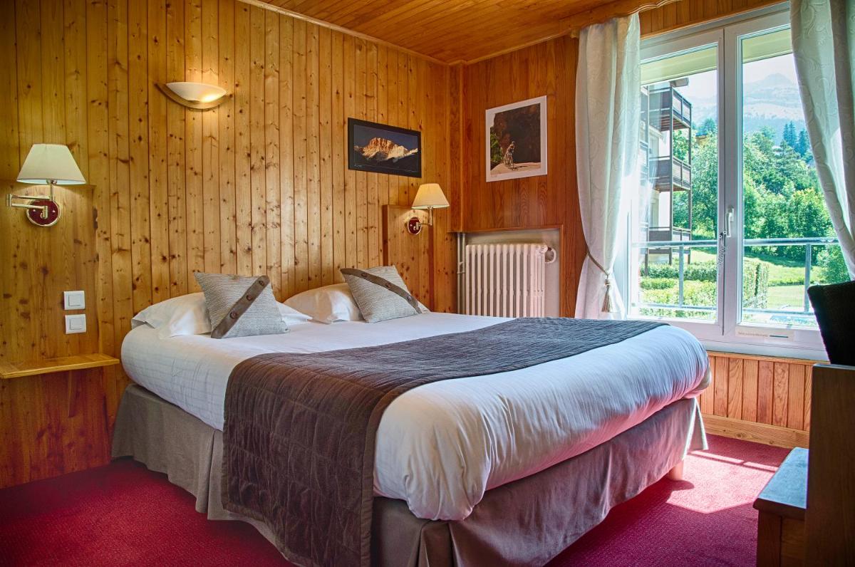 une chambre avec un grand lit avec une grande fenêtre dans l'établissement Joy Villard de Lans, à Villard-de-Lans 68 autres photos