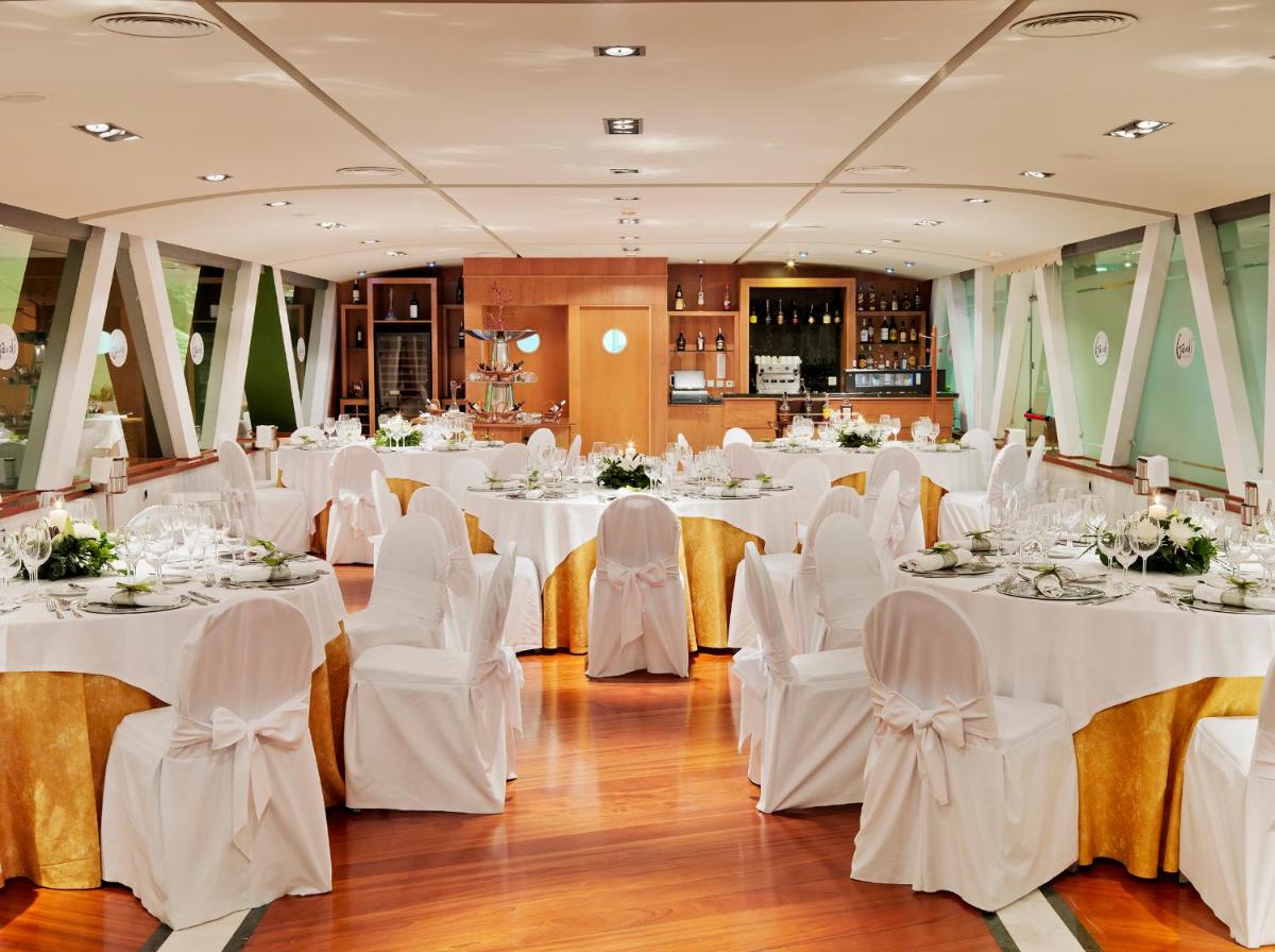 Un salón de banquetes con mesas y sillas blancas. en H10 Playa Meloneras Horizons Collection, en Meloneras