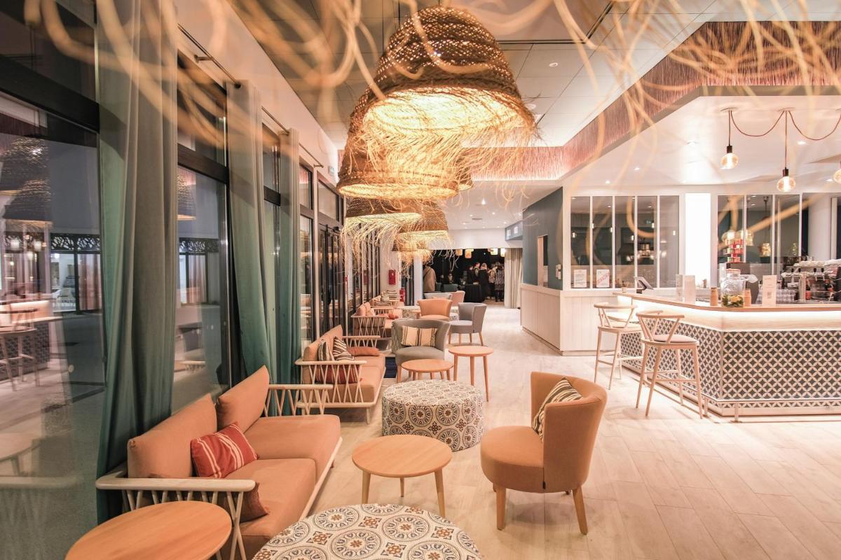 un restaurant avec des chaises et des tables et un bar dans l'établissement Belambra Clubs Port Camargue - Les Salins, au Grau-du-Roi