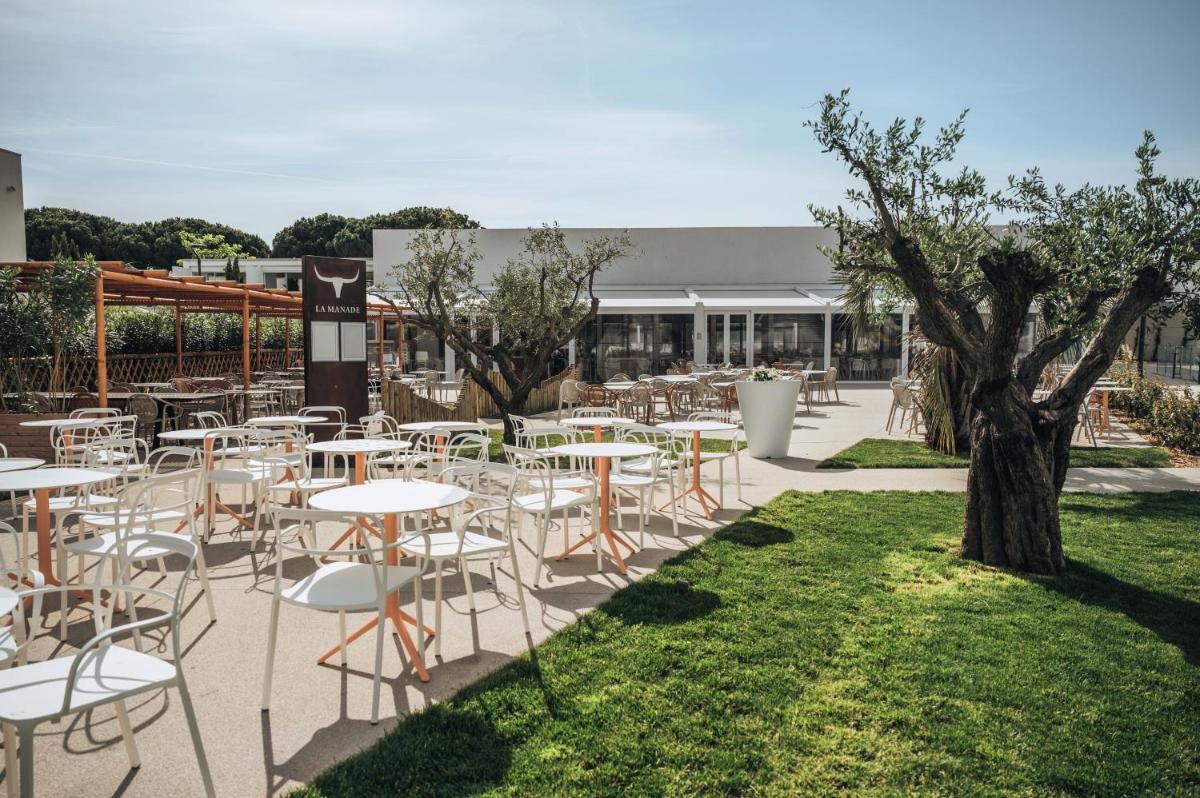 - un ensemble de tables et de chaises dans un jardin dans l'établissement Belambra Clubs Port Camargue - Les Salins, au Grau-du-Roi