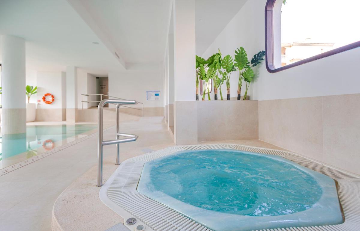 bañera de hidromasaje en una habitación con piscina en Marins Playa, en Cala Millor