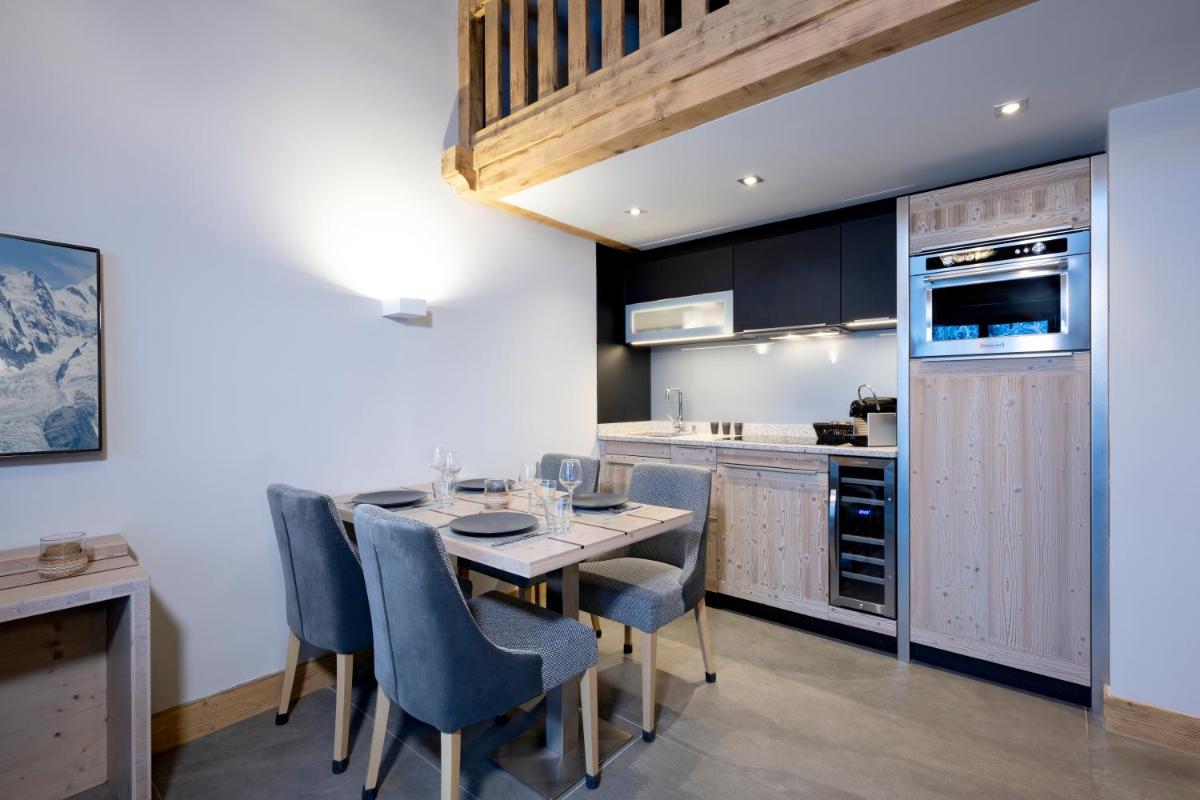 une cuisine avec une table et des chaises de salle à manger dans l'établissement MGM Hôtels & Résidences - Résidence Chalets Elena, aux Houches