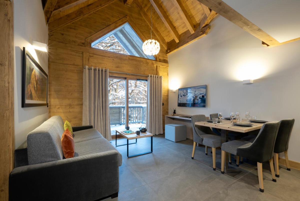 un salon avec une table et une salle à manger dans l'établissement MGM Hôtels & Résidences - Résidence Chalets Elena, aux Houches