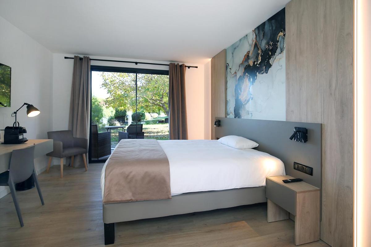 Un ou plusieurs lits dans un hébergement de l'établissement Logis Hôtel & Spa Déjeunez Sous L'Arbre