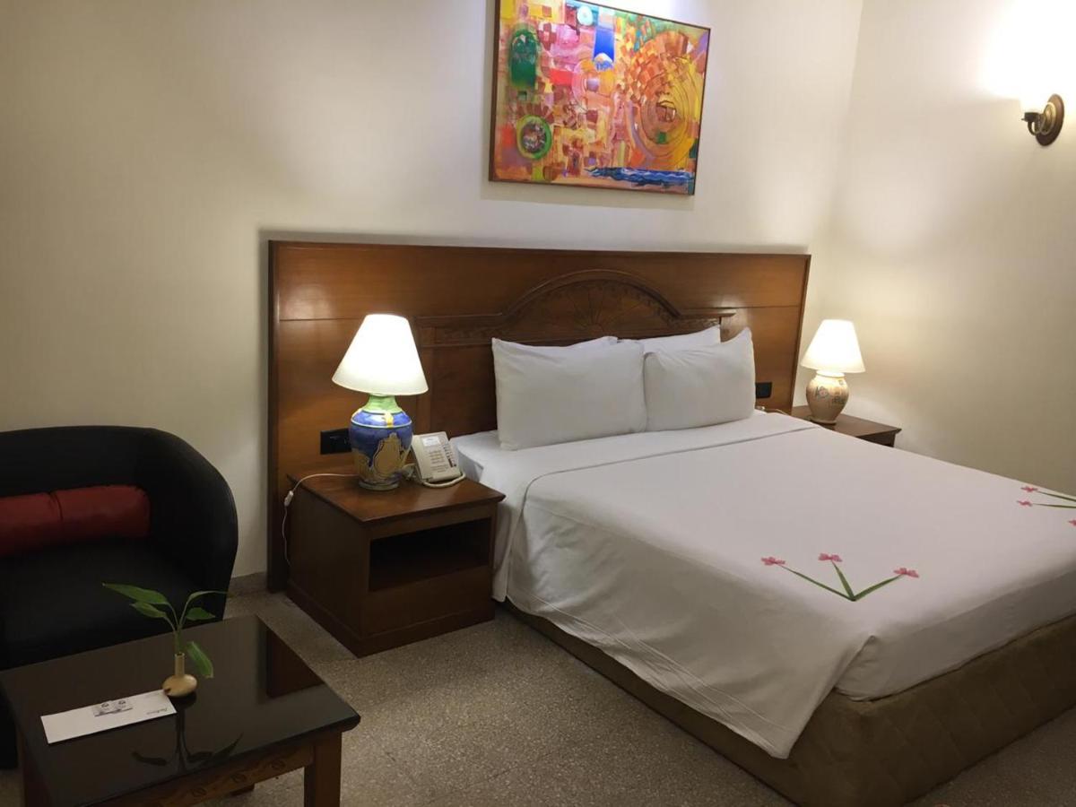 a hotel room with a bed and a chair at Radisson Goa Candolim in Candolim