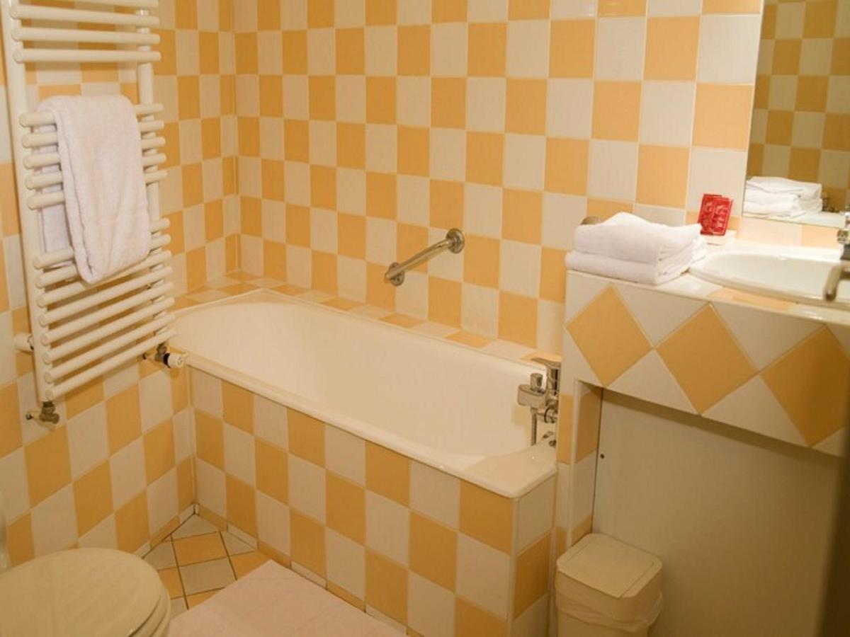 une salle de bain avec une baignoire et un lavabo dans l'établissement Hotel La Bougnate, à Blesle
