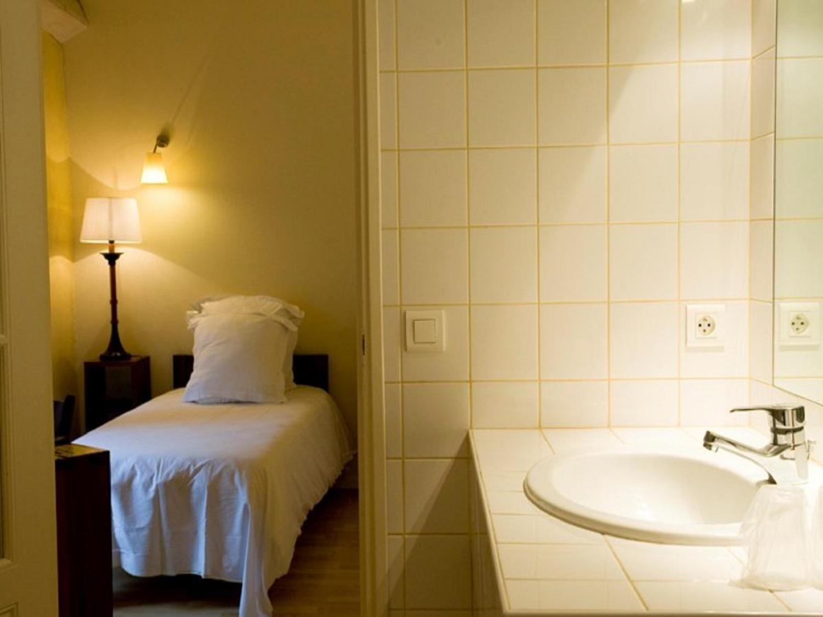 La salle de bains est pourvue d'un lit et d'un lavabo. dans l'établissement Hotel La Bougnate, à Blesle