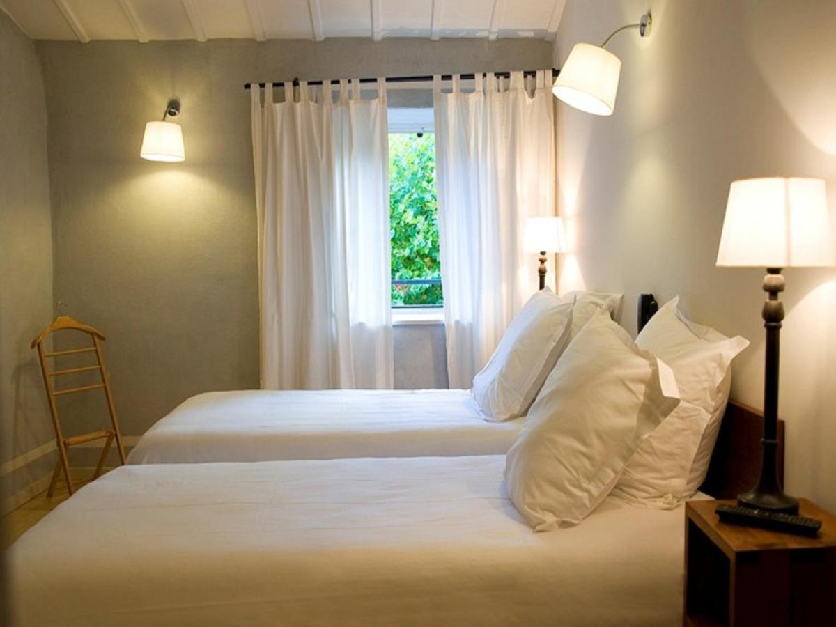 - une chambre avec 2 lits avec des oreillers blancs et une fenêtre dans l'établissement Hotel La Bougnate, à Blesle